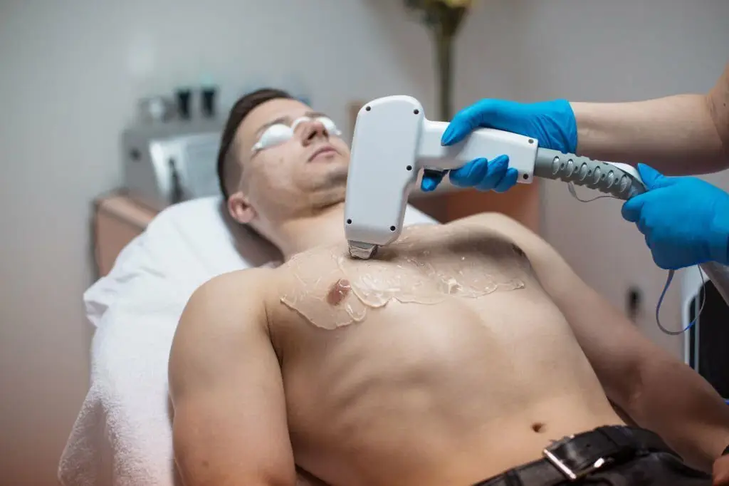 Man removing his chest hair with laser epilator